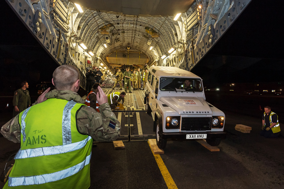A Land Rover is loaded into the hold of the C-17