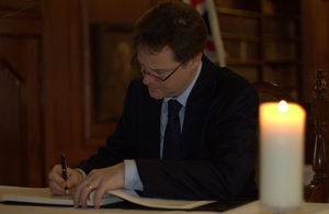 Nick Clegg signing a book of condolence for Nelson Mandela at South Africa House.