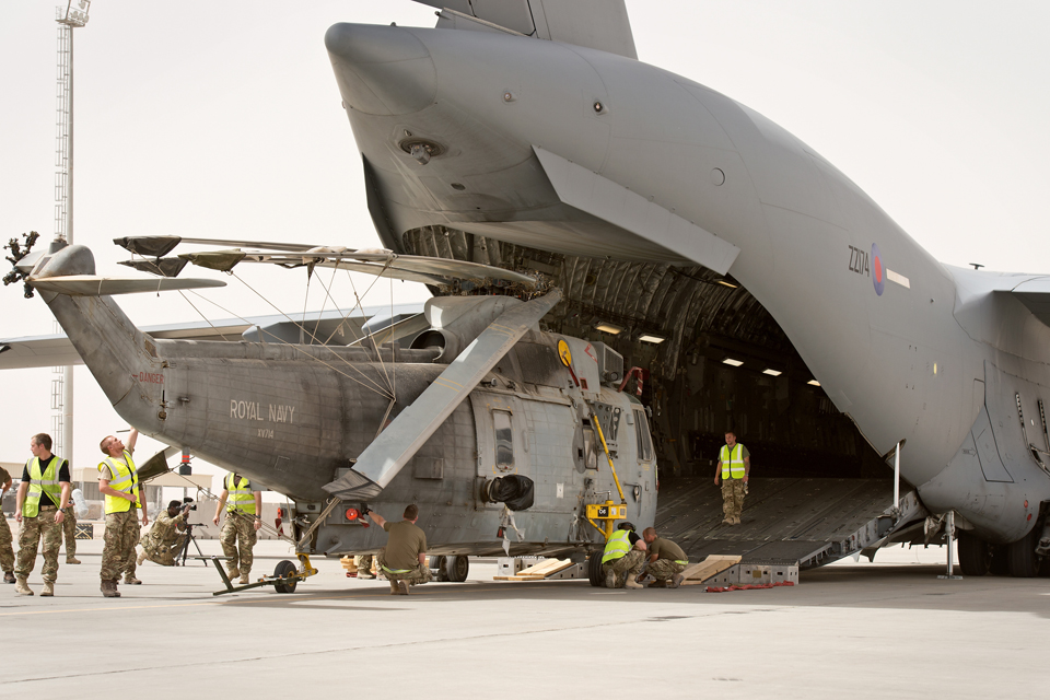 A Royal Navy Sea King helicopter being loaded onto an RAF C-17 aircraft