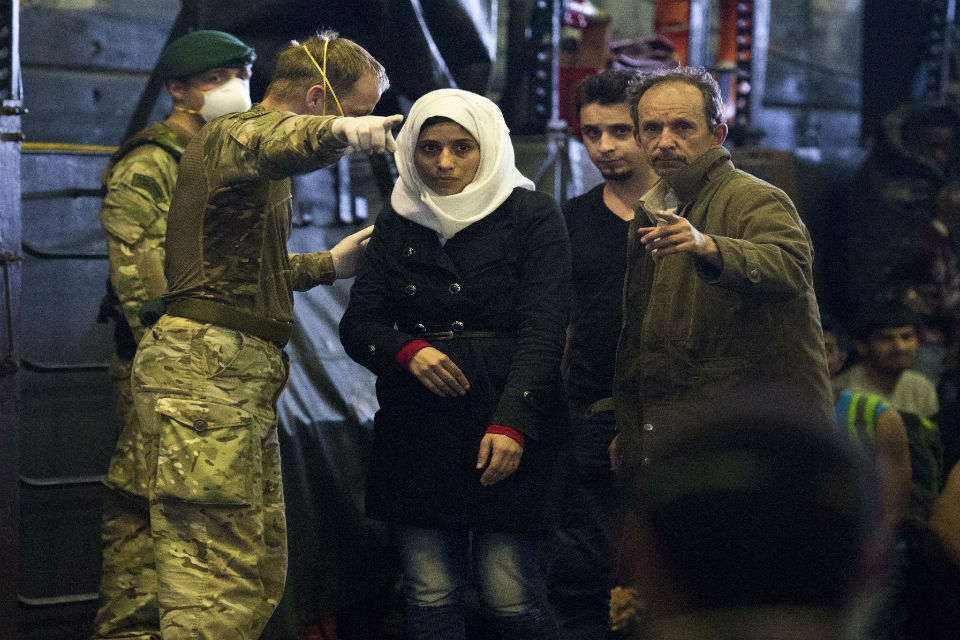 Migrants arrive on HMS Bulwark having been rescued by the Royal Navy in the Mediterranean
