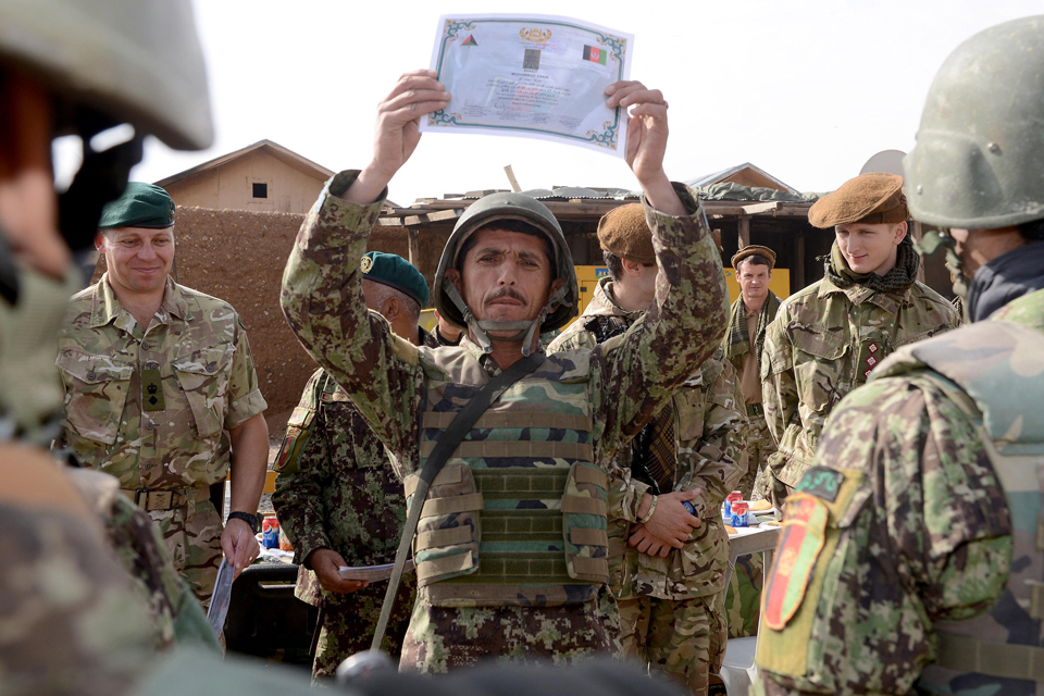 A newly-qualified Afghan soldier proudly displays his certificate