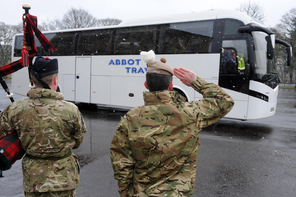 A bagpiper and senior officer salute the departing troops at Glencorse Barracks